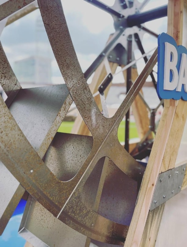 Close view of the weathered water-wheel construction and Bar Le Duc signage