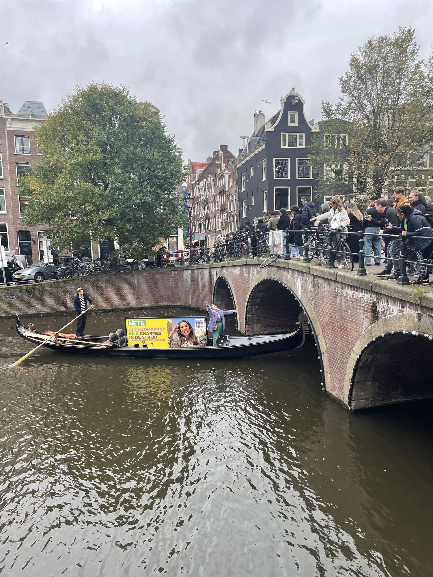Net5 gondola approaching an Amsterdam canal bridge with the campaign board on deck