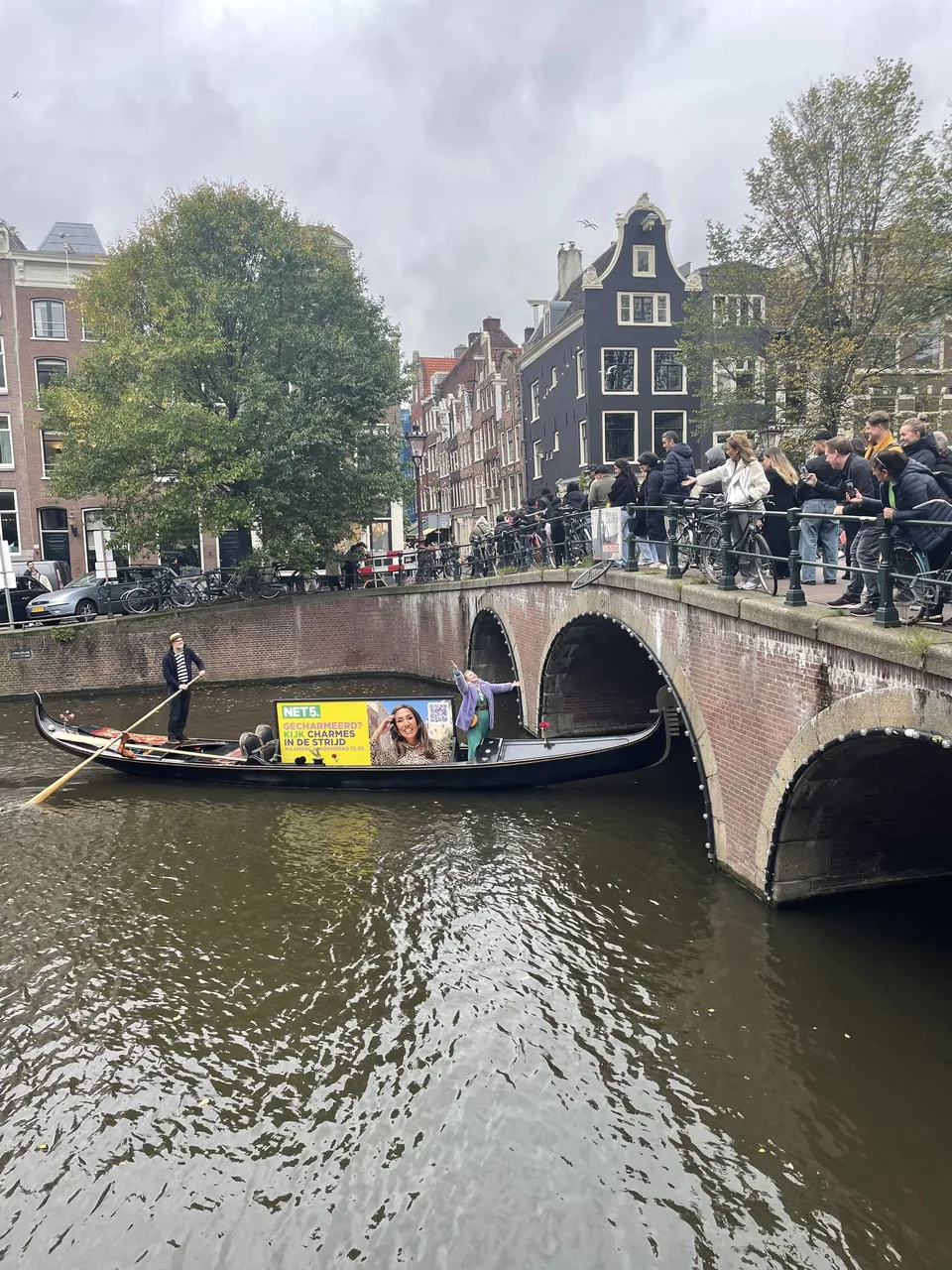 NET5 gondola approaching an Amsterdam canal bridge with the campaign board on deck