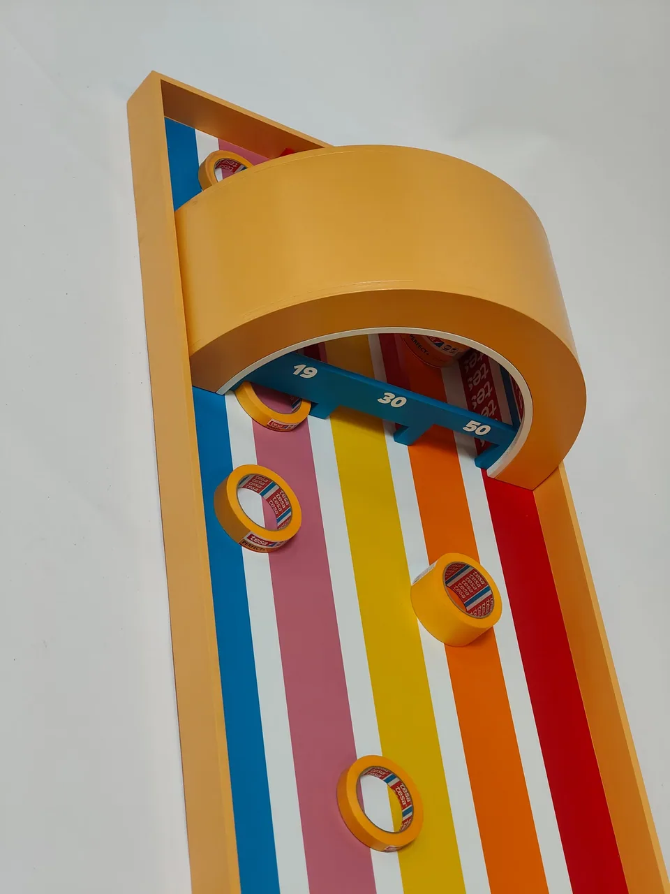 Overhead detail of tesa tape-roll pucks on the coloured lanes