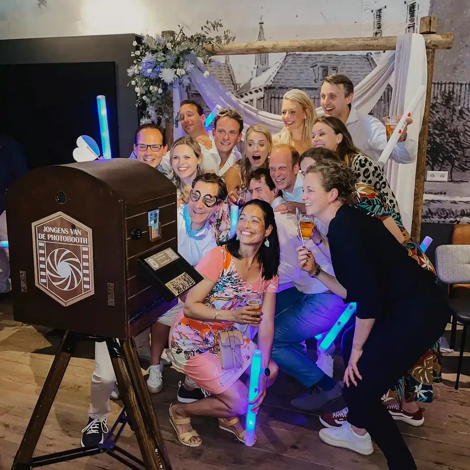 Wedding guests posing together in front of the wooden To Go Photobooth